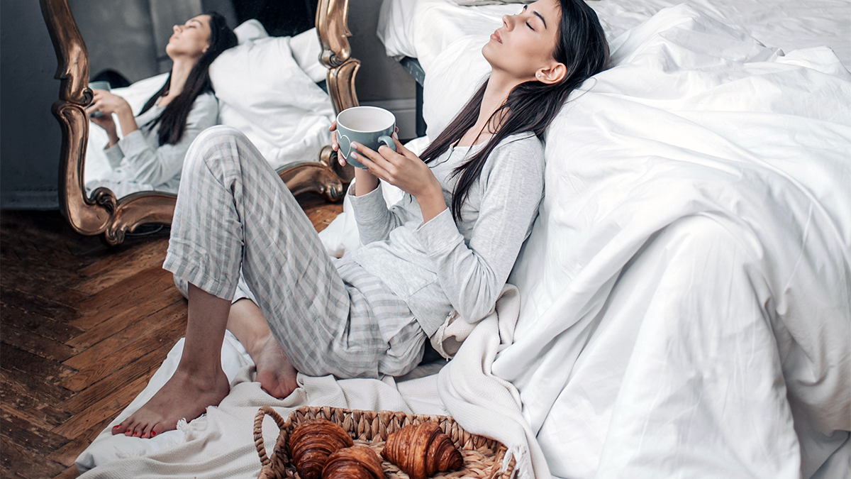 a photo of mother's day ideas: mom relaxing in bedroom with coffee and croissants