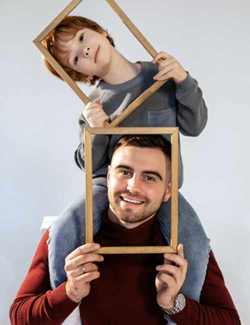 a photo of mother's day ideas: father and son posing with picture frames
