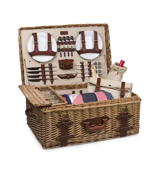 A photo of picnic with an open picnic basket full of cutlery and other tools