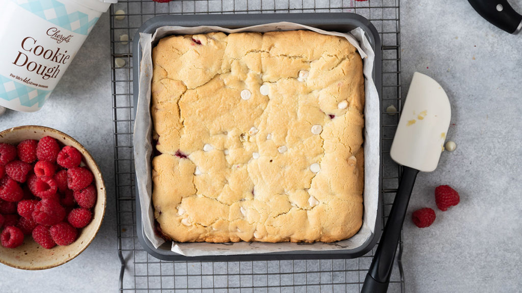 a photo of raspberry white chocolate with a pan of baked raspberry white chocolate bars