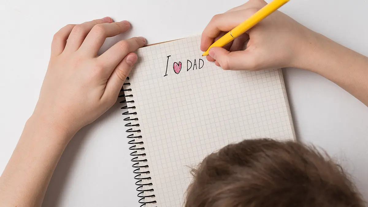 A photo of father's day messages with son writing father's day note to dad