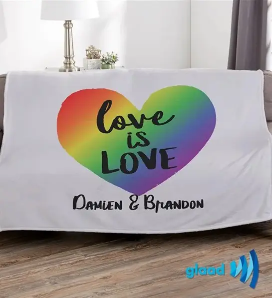 a photo of pride month gifts with a pride blanket