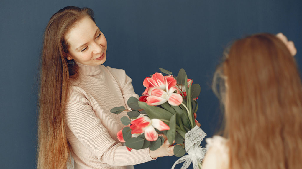 a photo of psychology of gifting with mom receiving flowers from daughter
