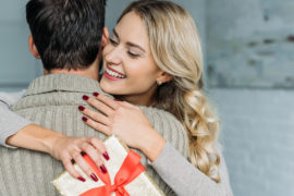 a photo of psychology of gifting with a woman hugging a man after receiving a gift