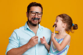 A photo of dad jokes with a dad joking with his daughter