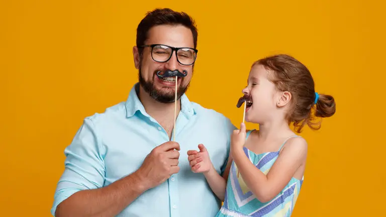 A photo of dad jokes with a dad joking with his daughter