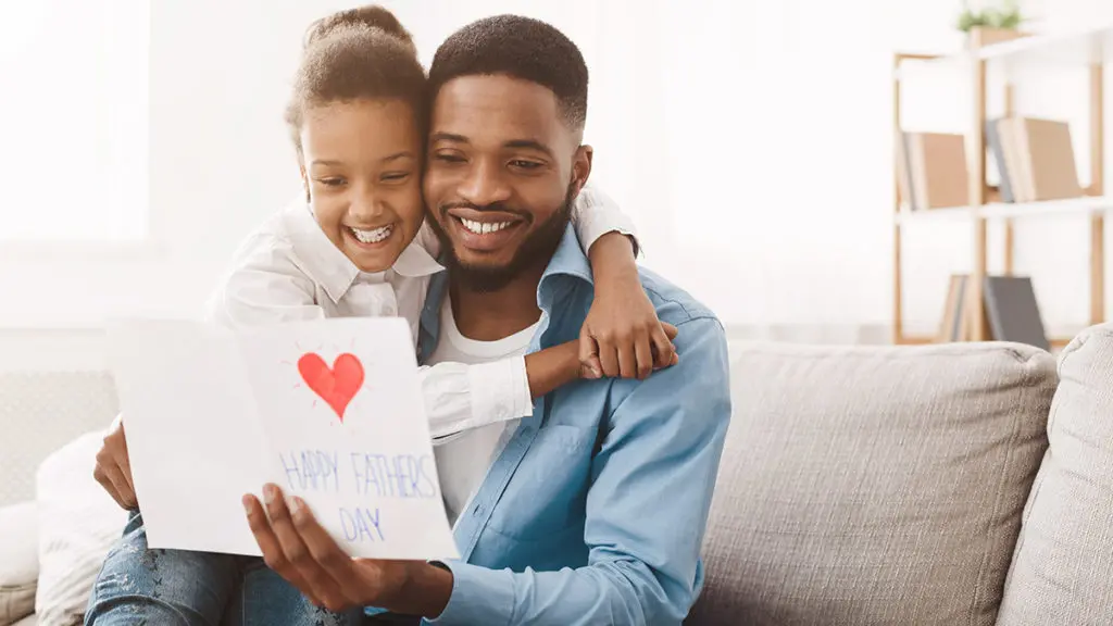 A photo of father's day ideas with daughter giving dad a father's day card