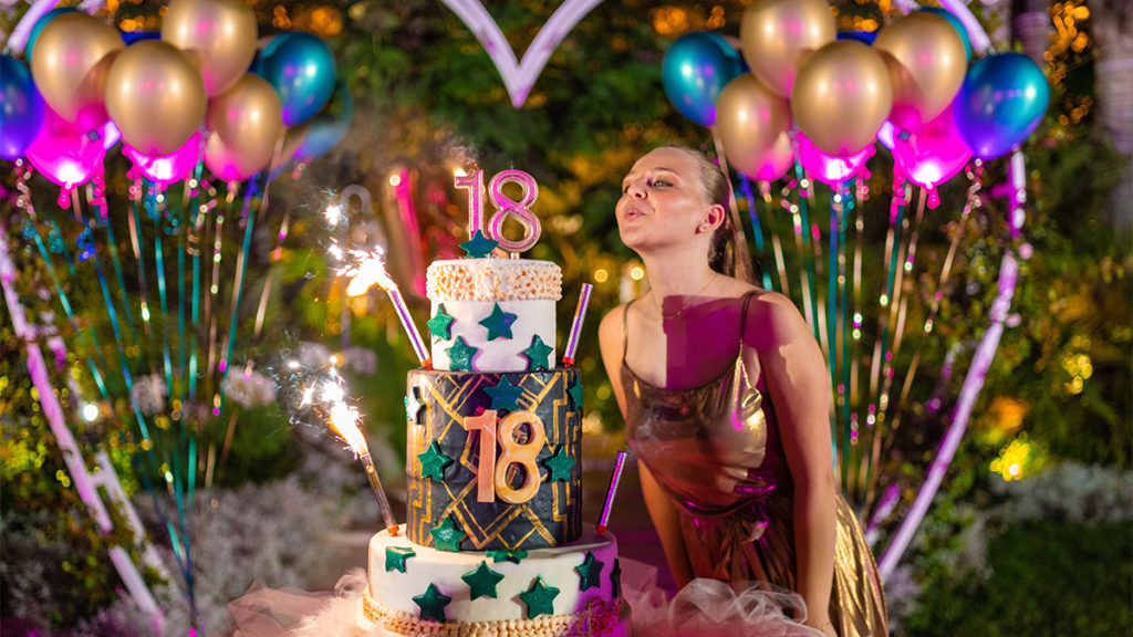 photo of 18th birthday ideas with girl blowing out candles on 18th birthday cake
