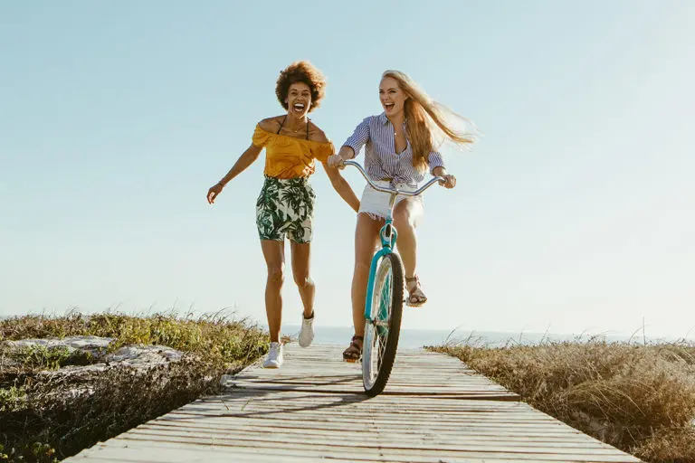 make the most of summer with girl riding a bicycle with a friend