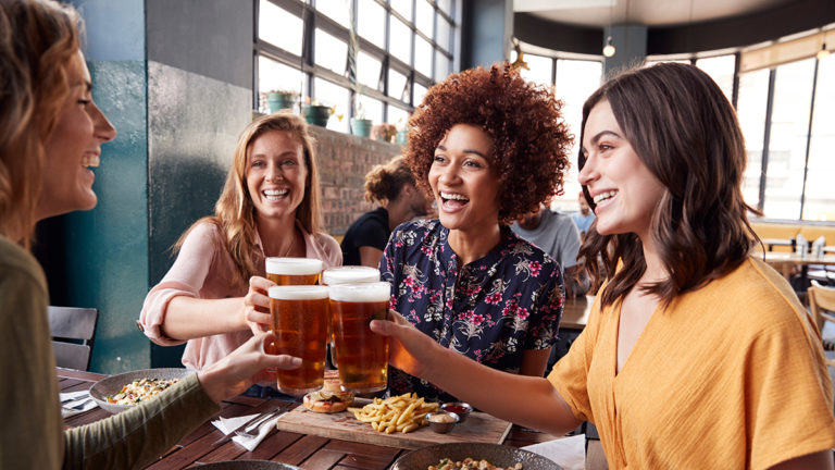 photo of alt bash with four young female friends meeting for drinks and food at a restaurant