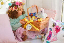 easter gifts a little girl sitting on a couch looking at an Easter basket.