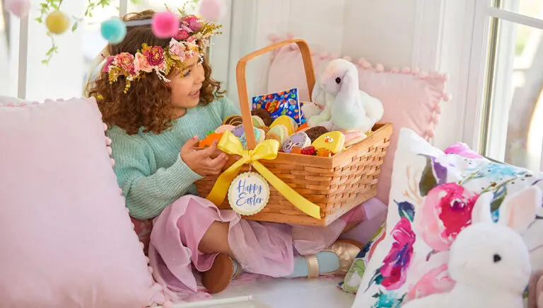 easter gifts a little girl sitting on a couch looking at an Easter basket.