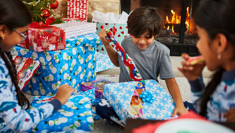 christmas food gifts being unwrapped by three children